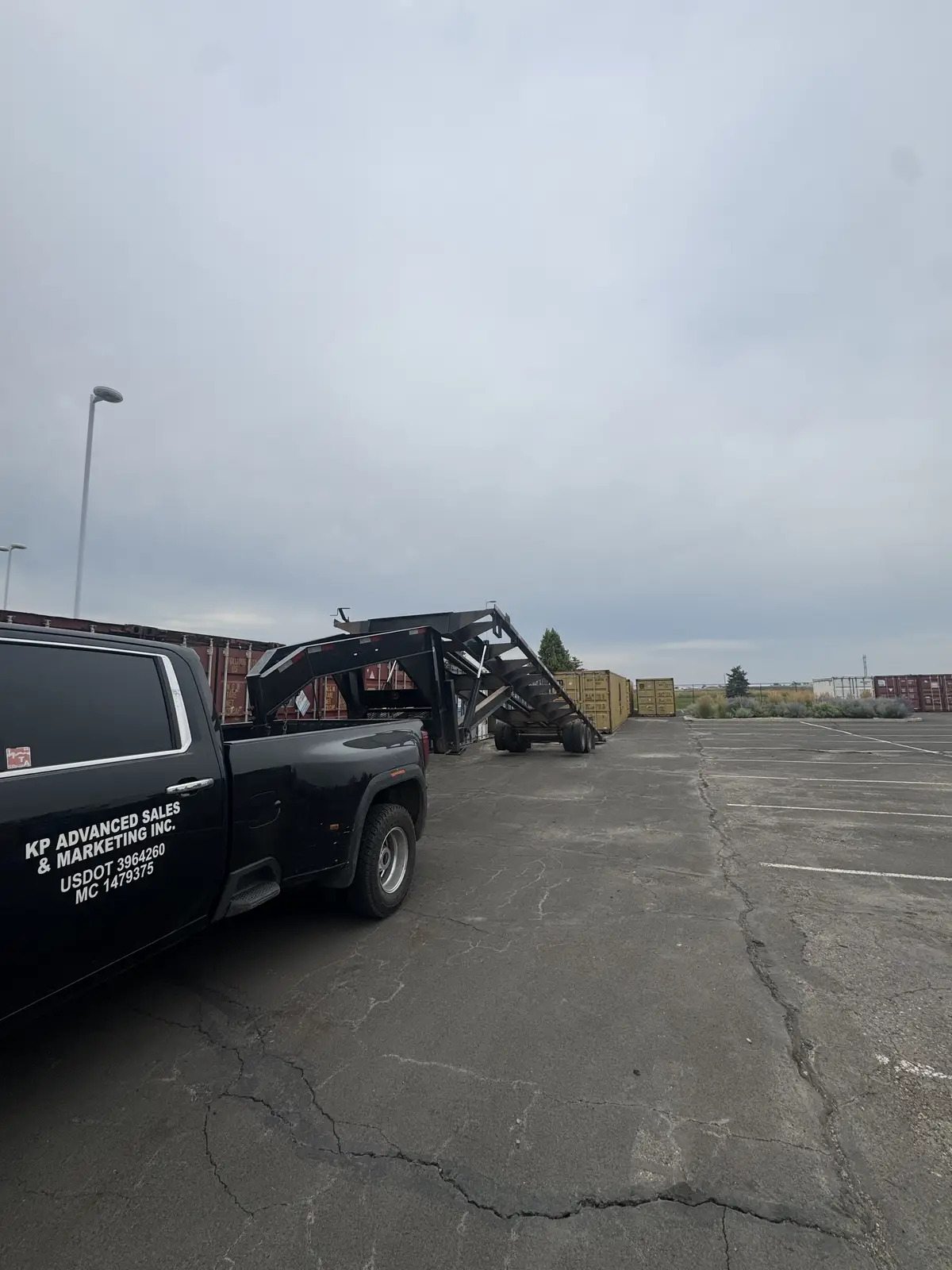 KP Storage Solutions branded truck with an empty gooseneck container trailer
