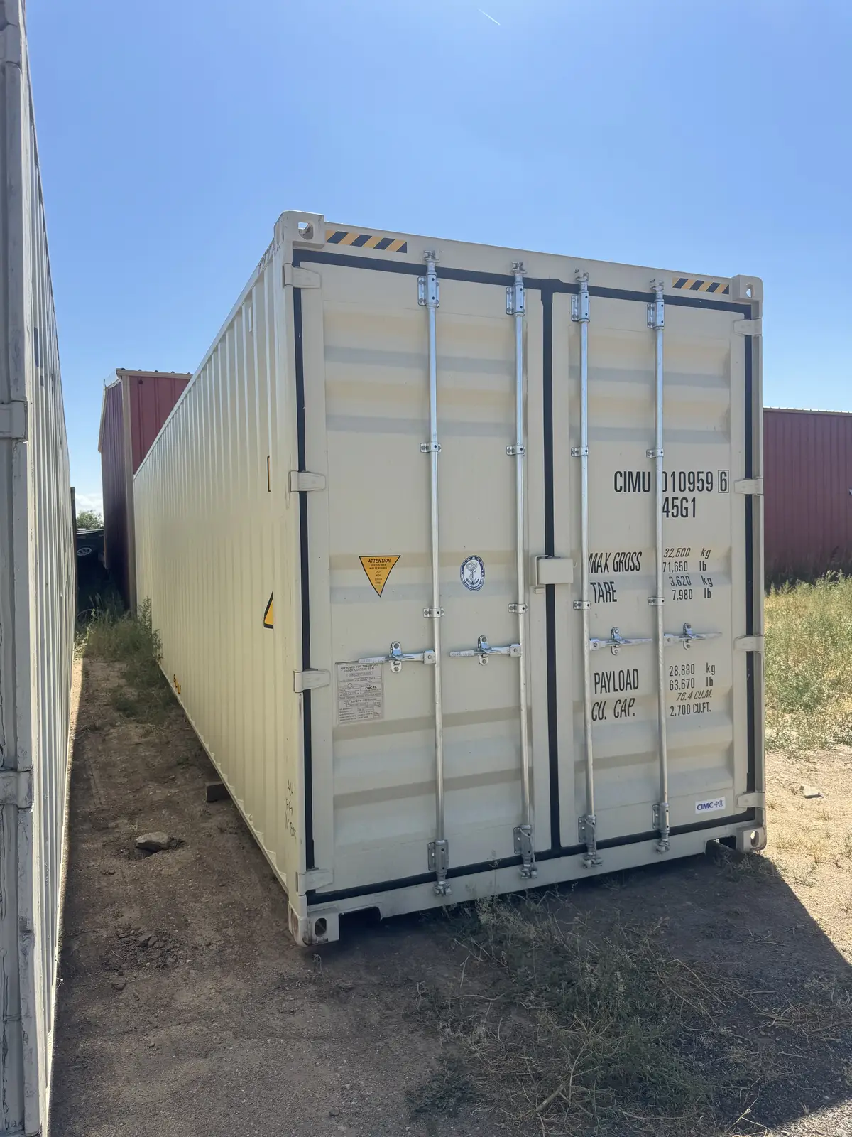 Close view of a clean tan shipping container with cargo doors and markings