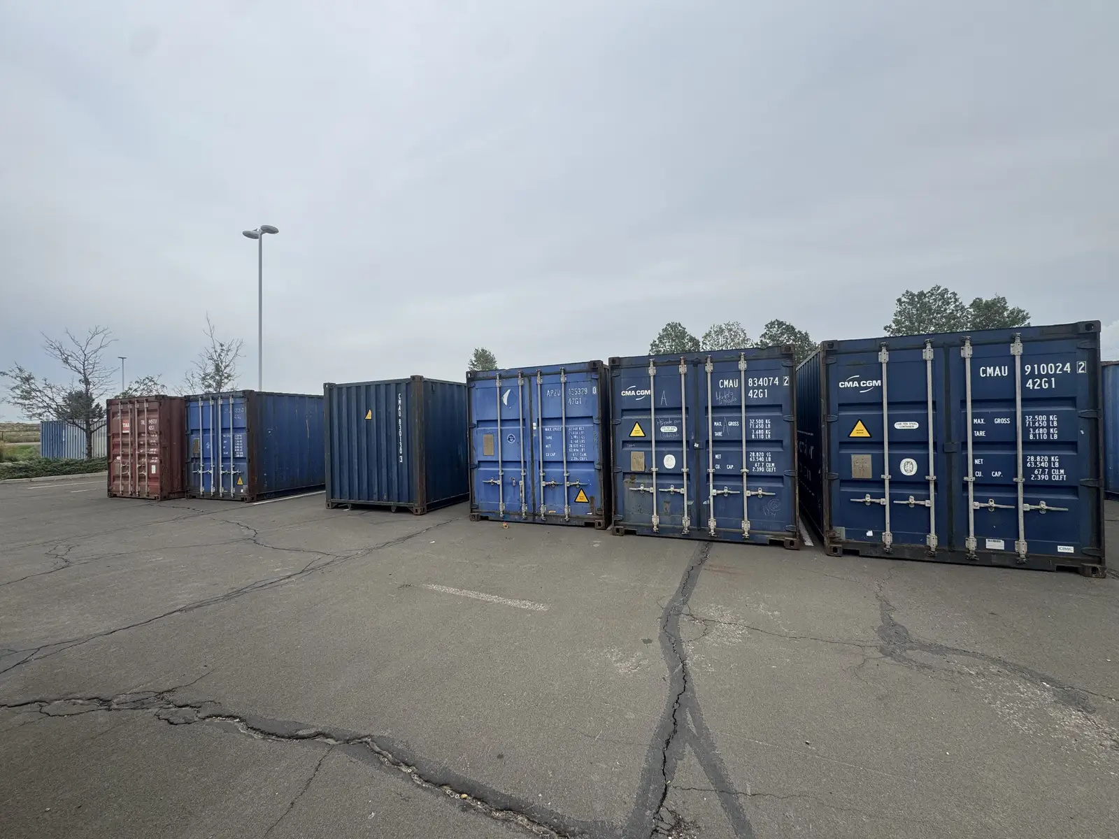 Rows of blue and tan shipping containers in a Colorado container yard