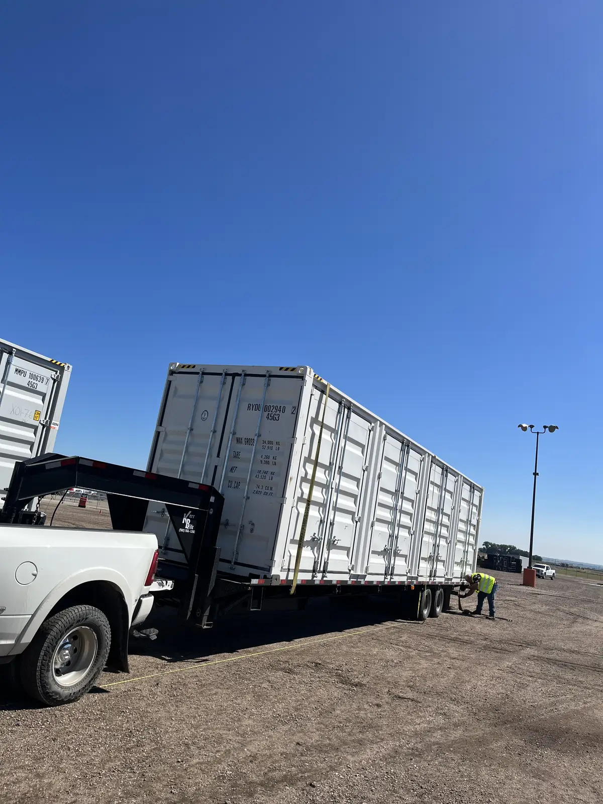 White multi-door shipping container on a gooseneck trailer
